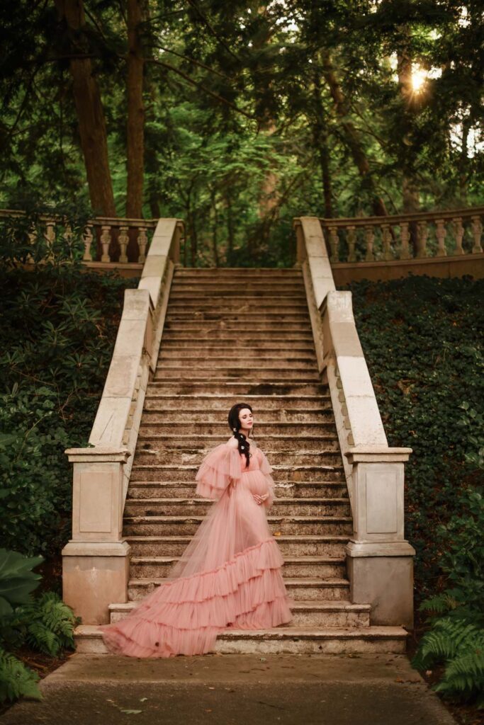 Expecting mother in a ruffled gown with the Cator Woolford Gardens grand stone staircase in the background in Atlanta, GA.