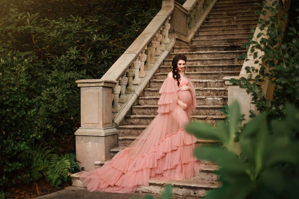 Expecting mother in a ruffled gown with the Cator Woolford Gardens grand stone staircase in the background in Atlanta, GA.