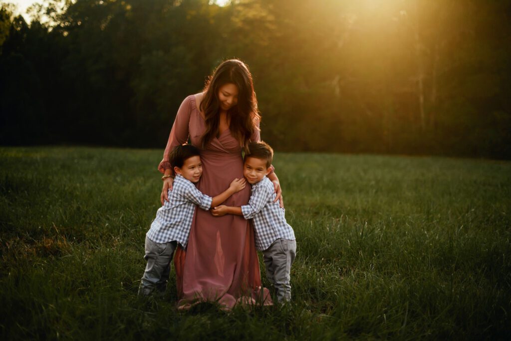 Mom standing with her two sons with Garrard Landing Park’s tall grass meadow in the background in Alpharetta, GA.