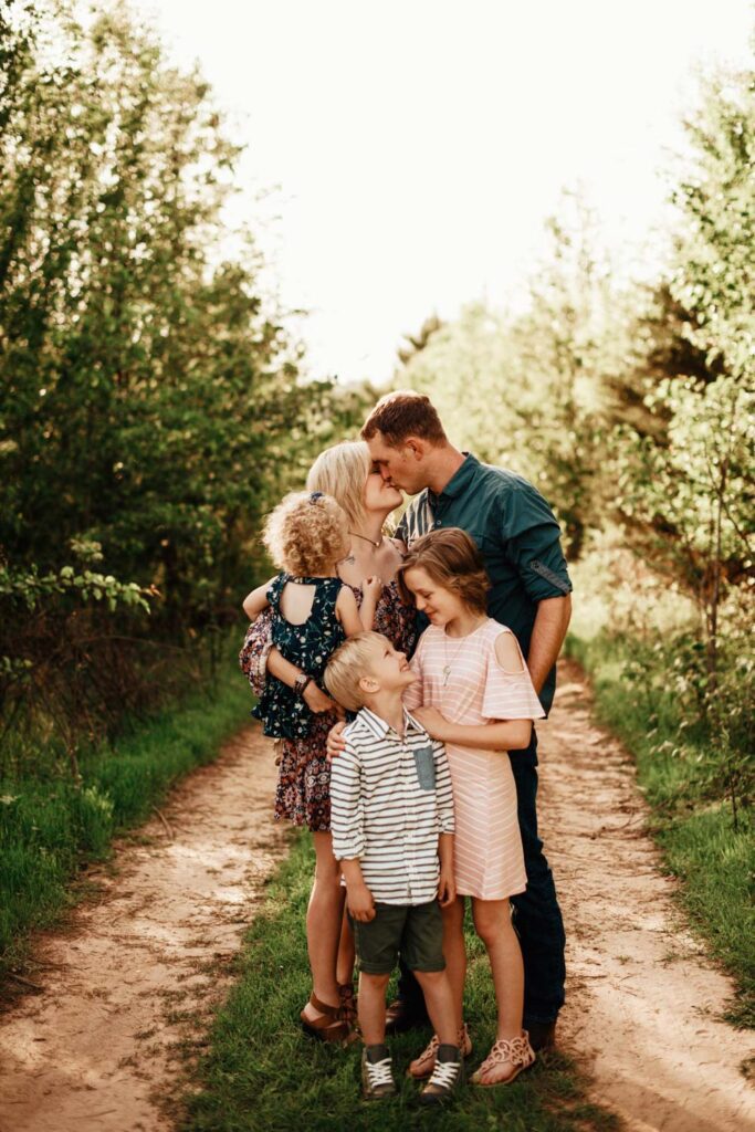 Family standing together on trail with Little Nancy Creek Park walking trail loop in the background in Buckhead, GA.