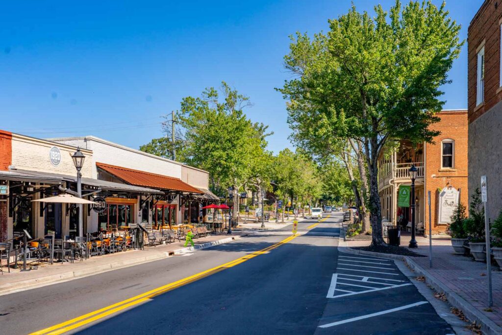 Canton Street in downtown Roswell, GA, with outdoor dining at 1920 Tavern, brick storefronts, and leafy trees