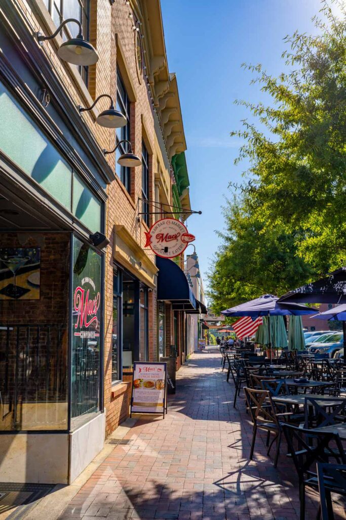 Brick sidewalk and outdoor dining tables outside Mac’s Raw Bar & Market on Marietta Square, GA.