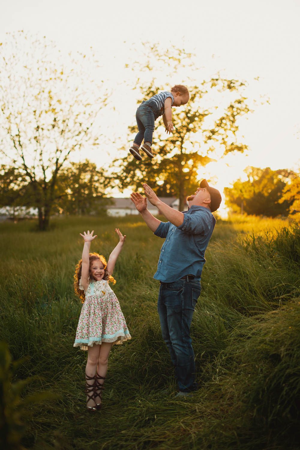 Father tossing son in the air at Cheatham Hill meadow with the Illinois Monument in background, Marietta GA