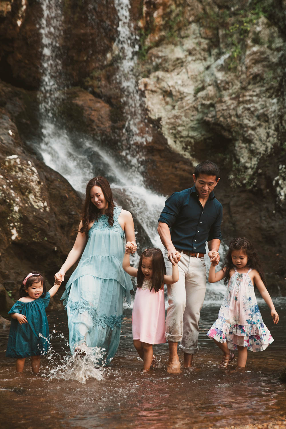 family walking through the creek with Roswell Mill waterfall in the background in Roswell, GA