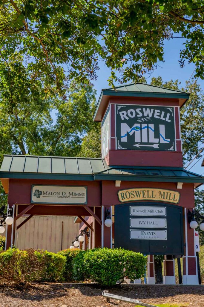 Roswell Mill entrance sign beneath leafy trees, listing Roswell Mill Club and Ivy Hall
