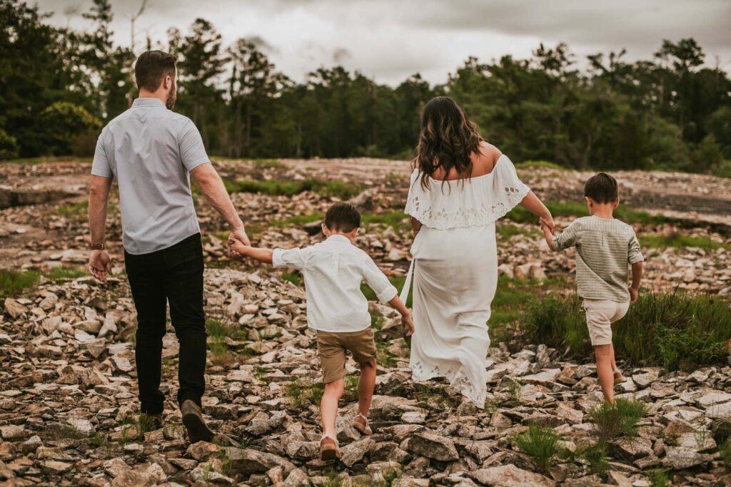 family walking together with the Arabia Mountain Quarry Ruins in the background in Stonecrest, GA during maternity session.