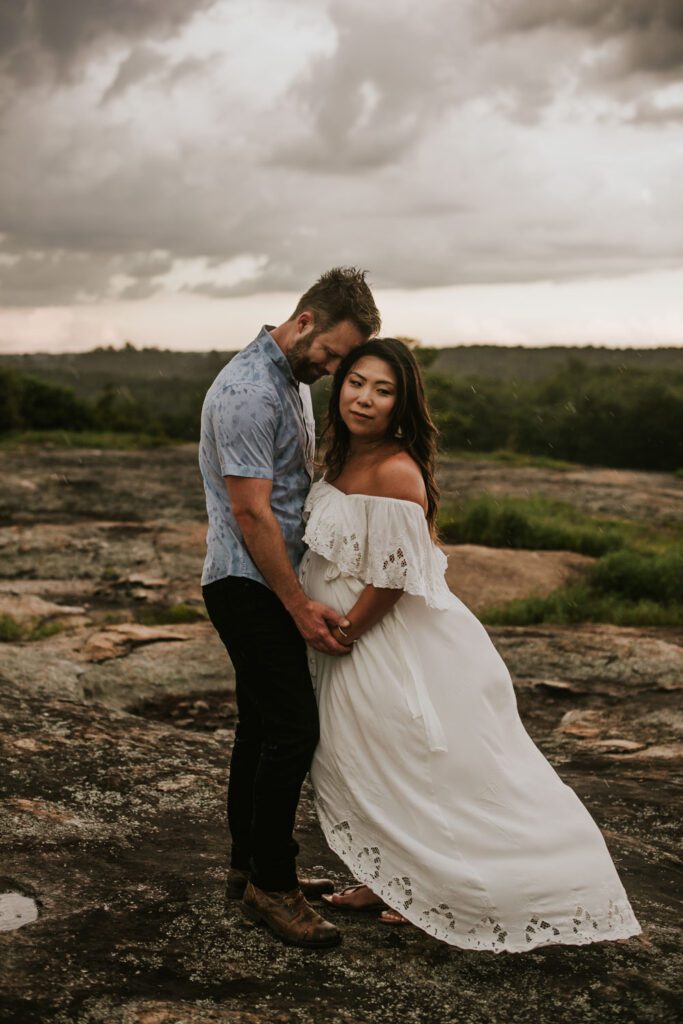 couple hugging with the Arabia Mountain Mile Rock Boardwalk in the background in Stonecrest, GA