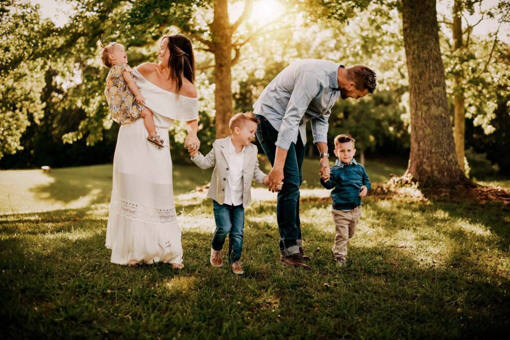 Family wearing matching clothes in shades of blue and white with the girls in dresses and the boys in jeans and khakis. 